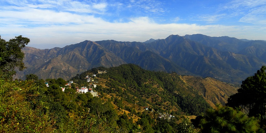 A glimpse of towering mountains adorned with lush green vegetation in Lansdowne.