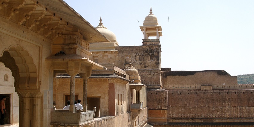 An image of a fort with ornate architecture, sandstone walls, and scenic hilltop view.