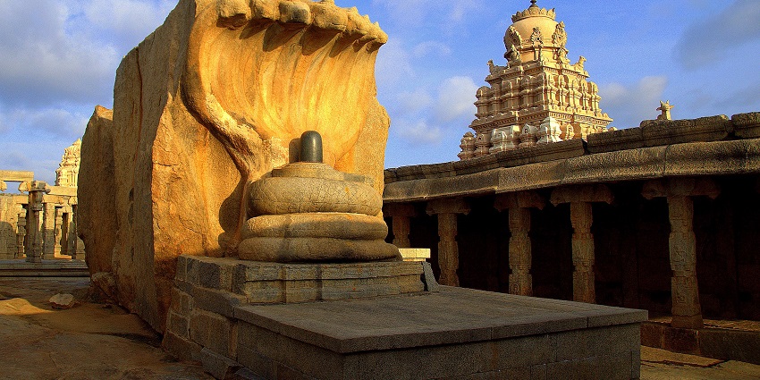 A picture of an ancient sculpture of a Shiva Linga being protected by a naga
