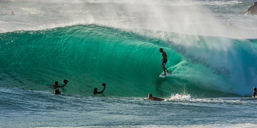 Stunning view of people enjoying surfing on high tides on a body of water during the day.