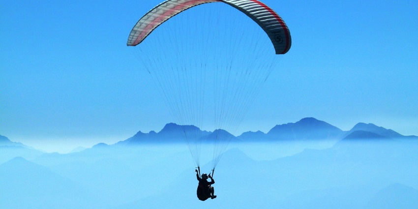 A person paragliding over clouds in the daytime and feeling the breeze in Kufri.