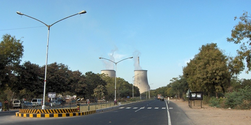 Gandhinagar road leading to Tapovan Temple, with clear skies and a scenic view.