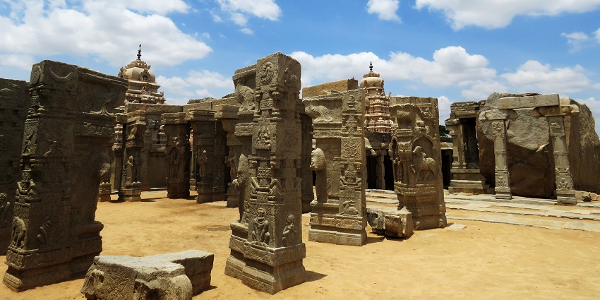 A serene temple courtyard, with ancient pillars standing full of intricate carvings reflecting heritage