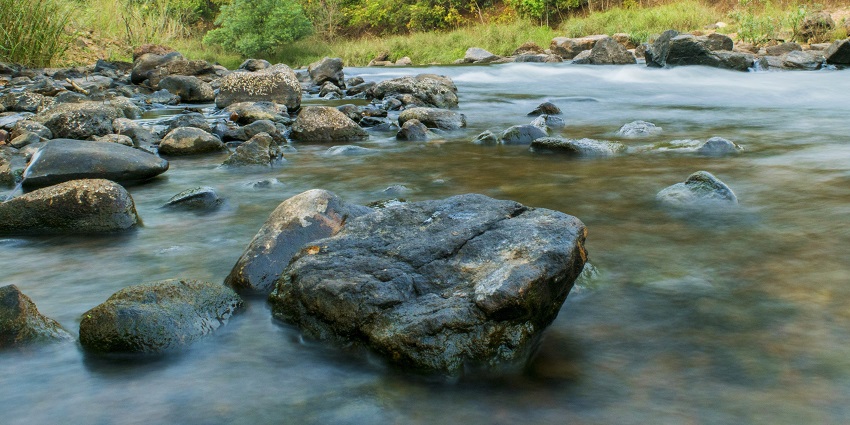 A picture of the famous Dharmatma waterfall cascading down a rocky hill