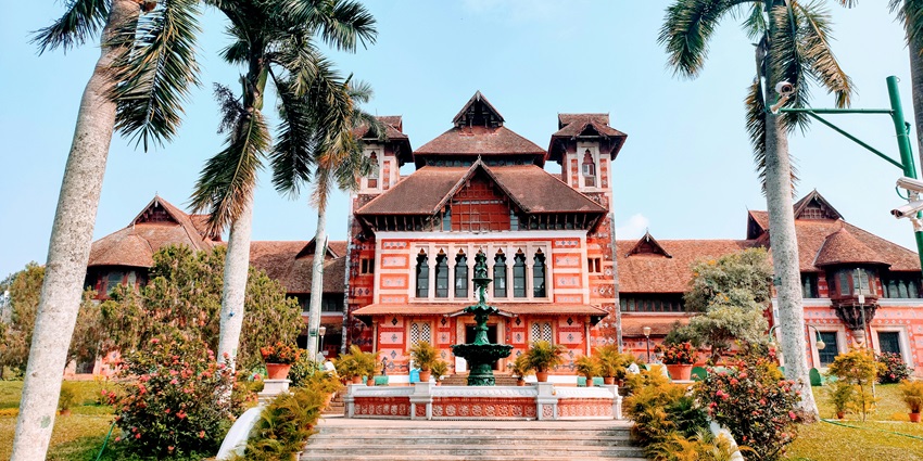 A brown and white wooden house nestled among lush green trees under a clear blue sky during the day