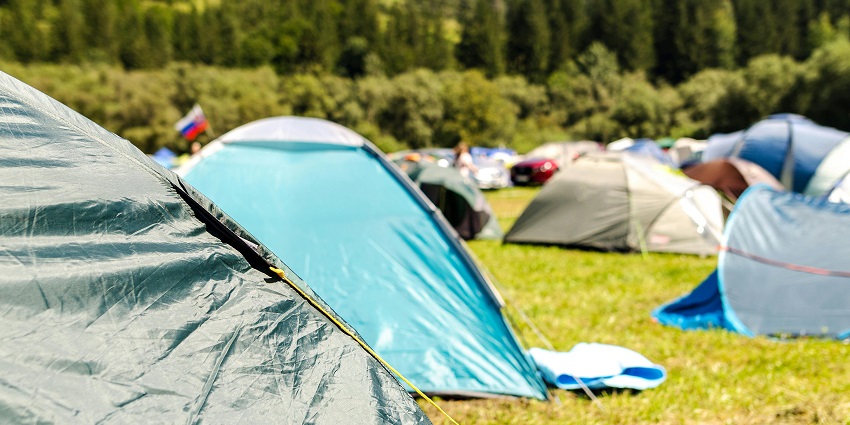 Image of tents surrounded by lush trees in a peaceful outdoor camping setting