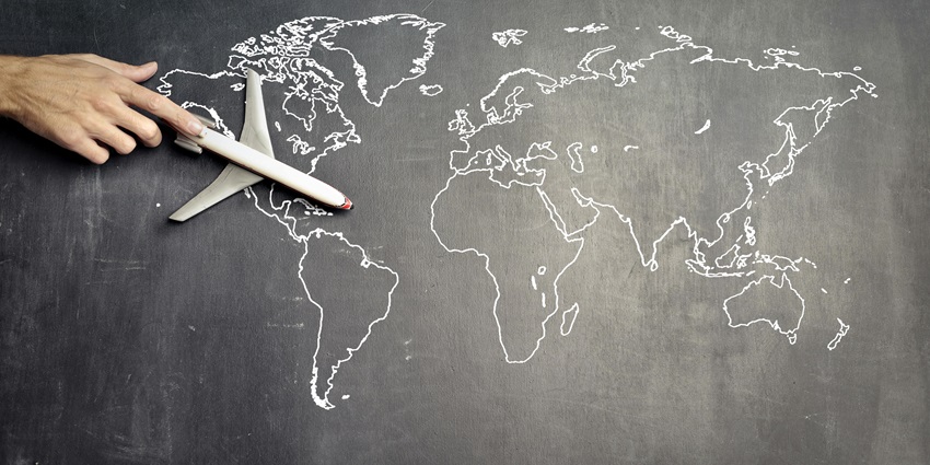 A frontal view of a blackboard with a white map drawn on it with a toy aeroplane on it.