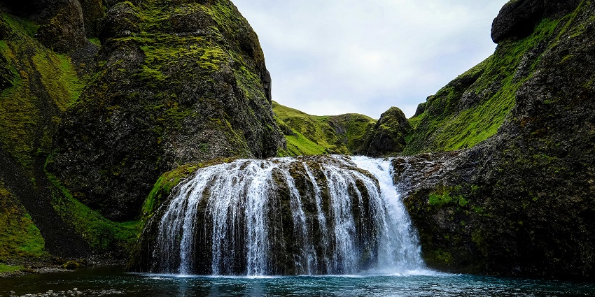 A breathtaking landscape featuring a cascading waterfall surrounded by lush greenery