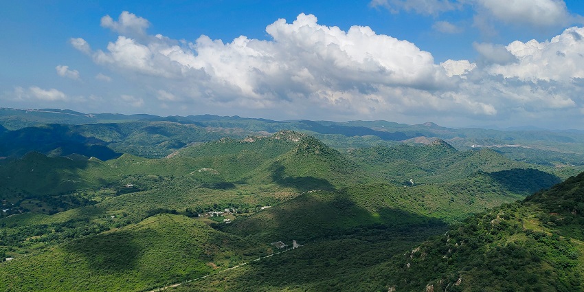 A breathtaking aerial view of Udaipur with lush green meadows during the daytime.