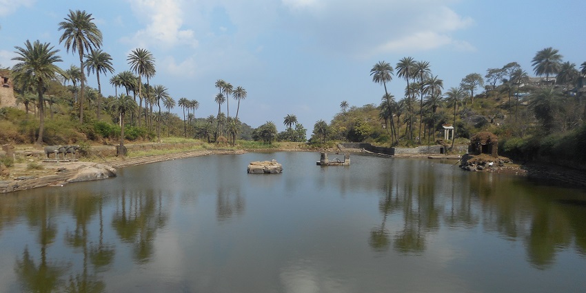 A serene view of a lake near the historic Achalgarh Fort, showcasing breathtaking views.