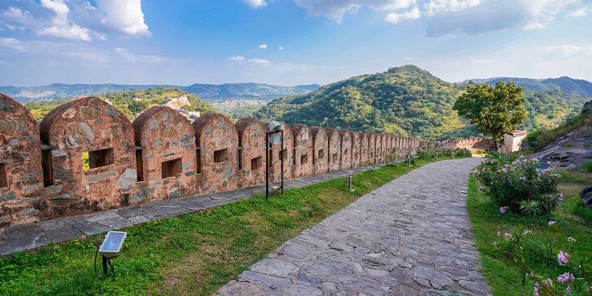 Aerial view of the top of the Kumbhalgarh Fort under clear blue sky and lush green hills surrounded