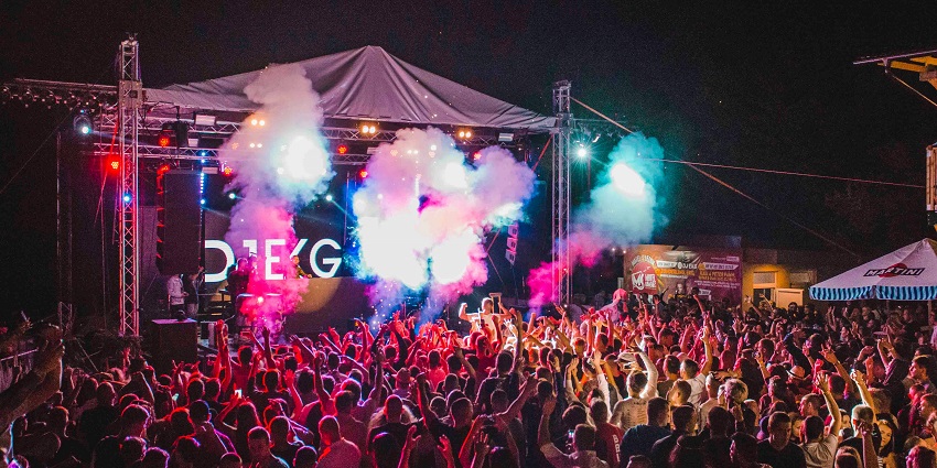 Festival lovers dancing and enjoying live music at the Bir Music Festival, surrounded by vibrant decorations