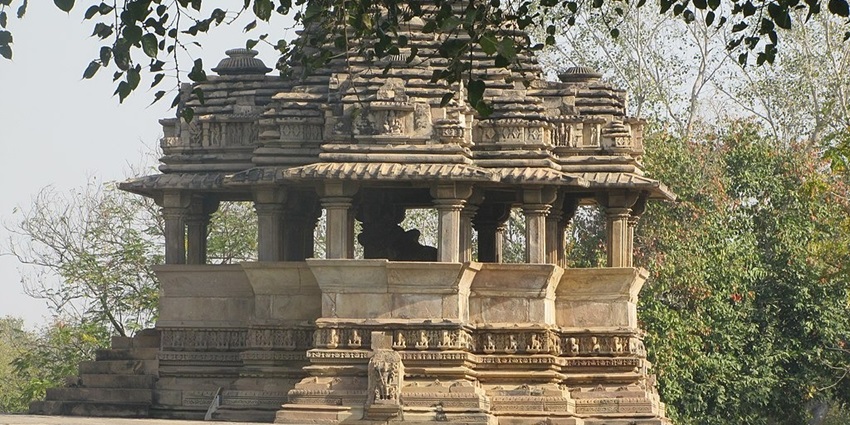 Exterior view of the Nandi Temple in Khajuraho, India, featuring detailed stone carvings and architectural elements.
