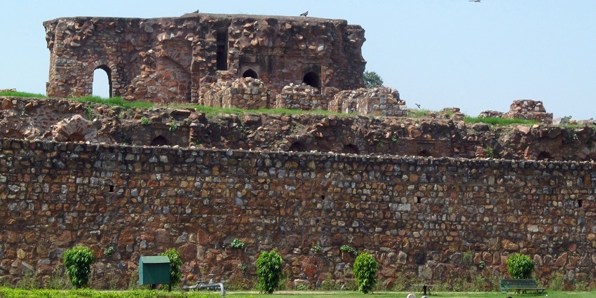 A picture of the ruins of the Feroz Shah Kotla Fort with a garden area in front of it's wall