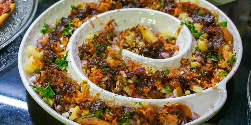 A glimpse of Locho being served on a designer plate, one of the best foods in Surat.