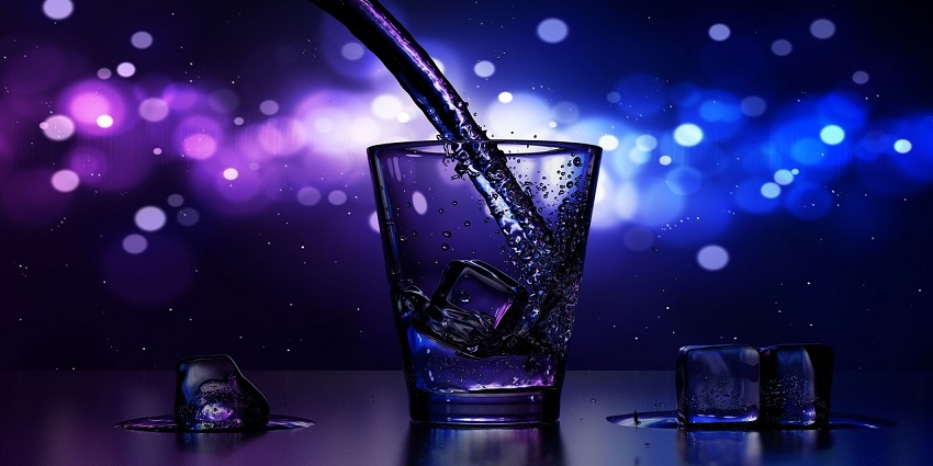 Glass with ice where water is being poured with a pipe. Ice on both sides of the glass.