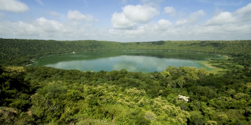 Saline soda lake in the crater, surrounded by forests and temples during the daytime.