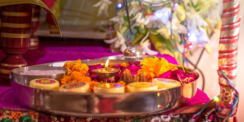 Image of Hindu pooja thali decorated with flowers and diya and other hindu ritual essentials