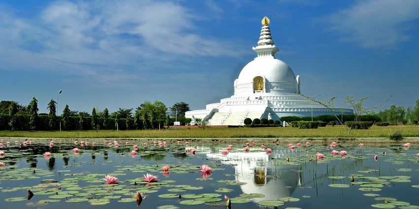 A picture of a monument in Nepal with a pond of lotus flowers. Obe of the best places to visit in Nepal in June