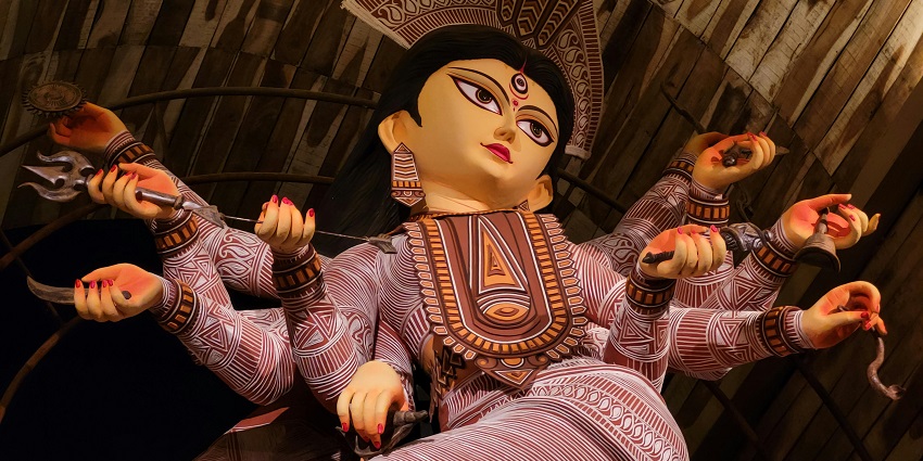 Close-up of a multi-armed Maa Durga statue, showcasing intricate details and vibrant colours.