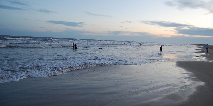 A picture of a beach near Vijayawada with small waves approaching the shore during twilight
