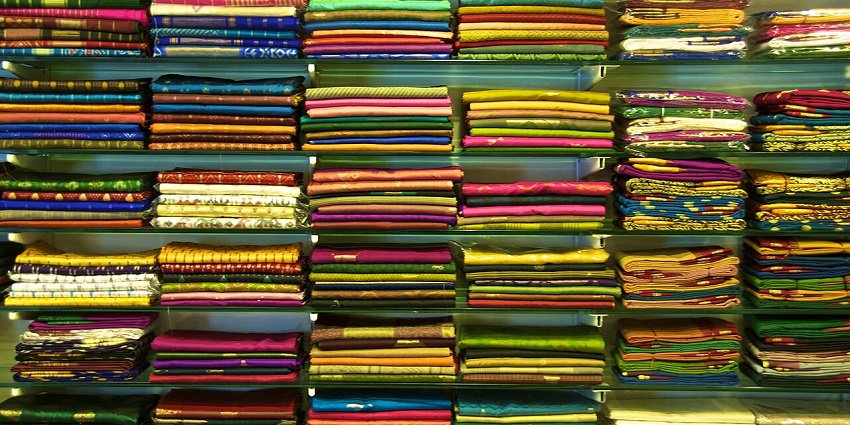 An amazing view of the shop with a wide display of colourful sarees on a shelf.