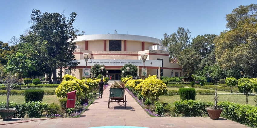 A picture of the complex of a historical museum with majestic gardens in front of the main building