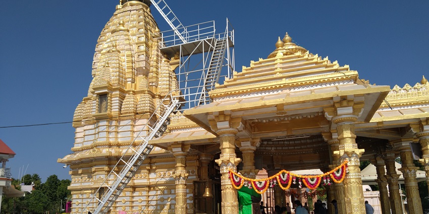 Image of a temple in golden architecture and devotees exploring the temple