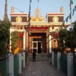 A breathtaking view of a monastery in Majnu Ka Tila with flags on top during the day.