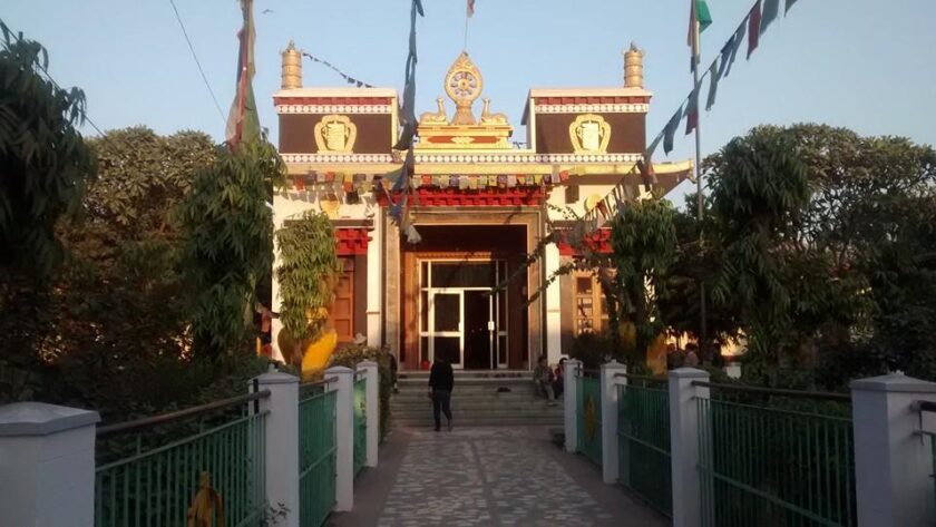 A breathtaking view of a monastery in Majnu Ka Tila with flags on top during the day.