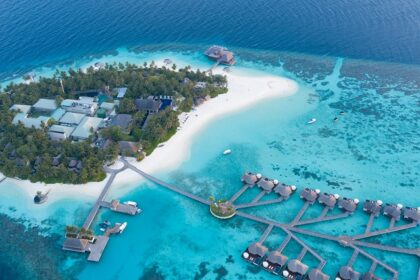 A bird’s eye view of the turquoise-blue waters and golden sands dotted with palm trees