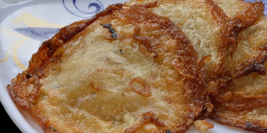 An image of Malpua which are deep-fried pancakes in sugar syrup, paired with rabri.