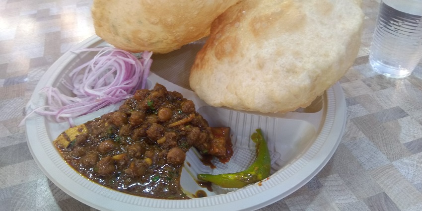 Chole bhature served with onions and green chilli, one of the most favourite dishes of the city