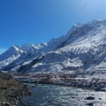 Snow-capped mountains in Manali, showcasing a stunning winter landscape under a clear blue sky.