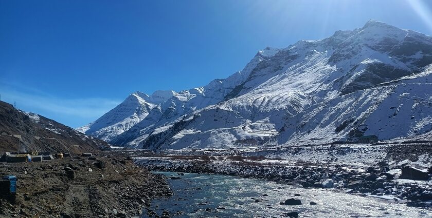 Snow-capped mountains in Manali, showcasing a stunning winter landscape under a clear blue sky.