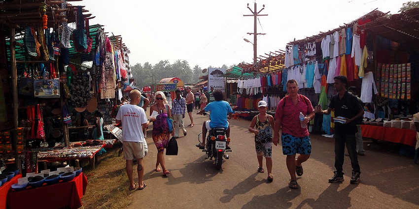 Image of one flea market in Goa, tourists and travellers exploring the market and vendors standing.