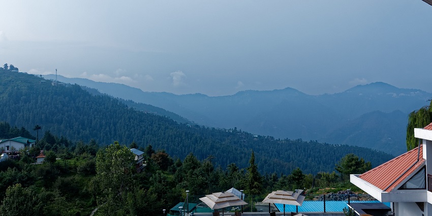 Scenic view of Mashobra town with lush green and some snow covered mountains
