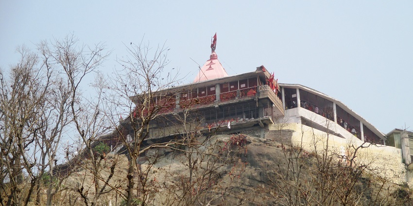 View of the Mansa devi temple atop a hill and surrounded by trees