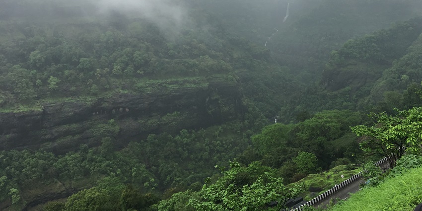 Scenic view of Matheran with lush greenery and a distant mountain range.