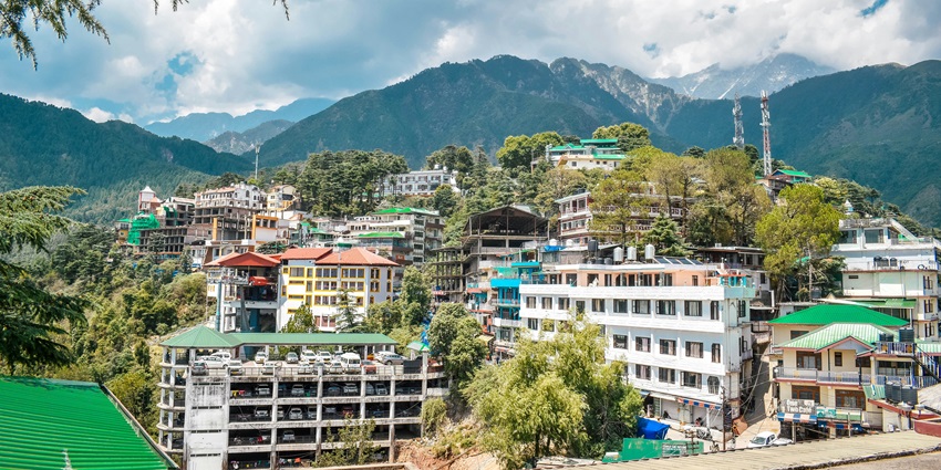 Scenic view of Mcleodganj with traditional buildings and a backdrop of misty mountains