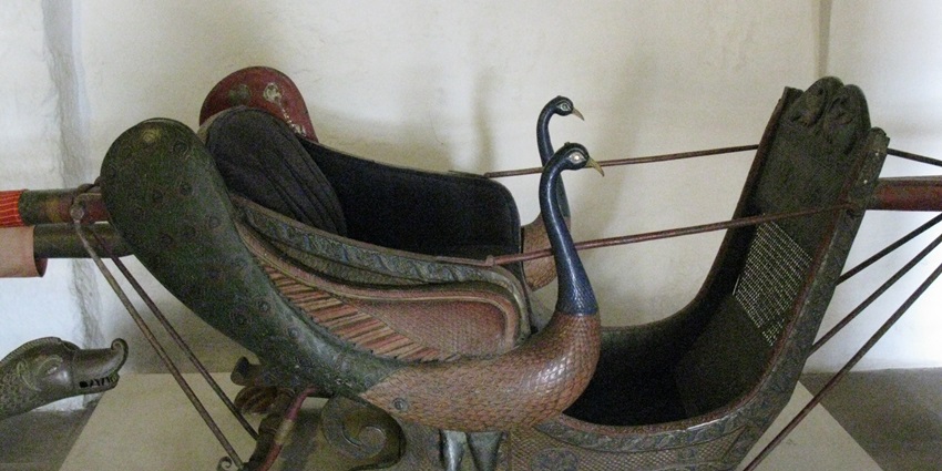 A beautifully carved wooden palanquin displayed at the Mehrangarh Fort Museum, a famous museum in Jodhpur.