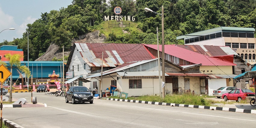 A scenic view of Mersing, showcasing lush greenery and a tranquil waterfront under a clear sky.