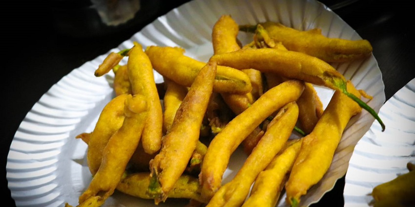 An image of Mirchi Bhajiya which is crunchy chili fritters with chutney, perfect for spice lovers.