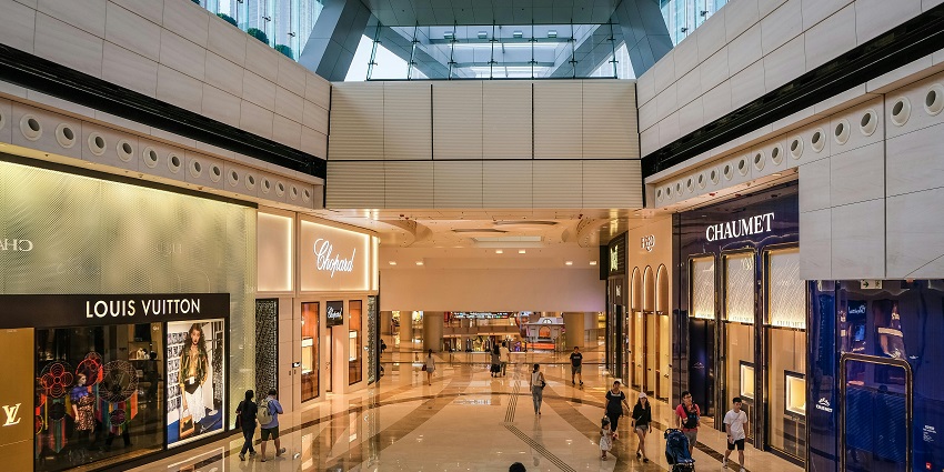 Aerial view of a modern shopping mall with parking and surrounding areas.