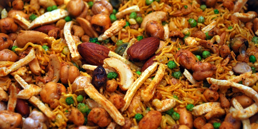 Colorful mixture of various spices and nuts in a bowl, showcasing vibrant textures and hues.