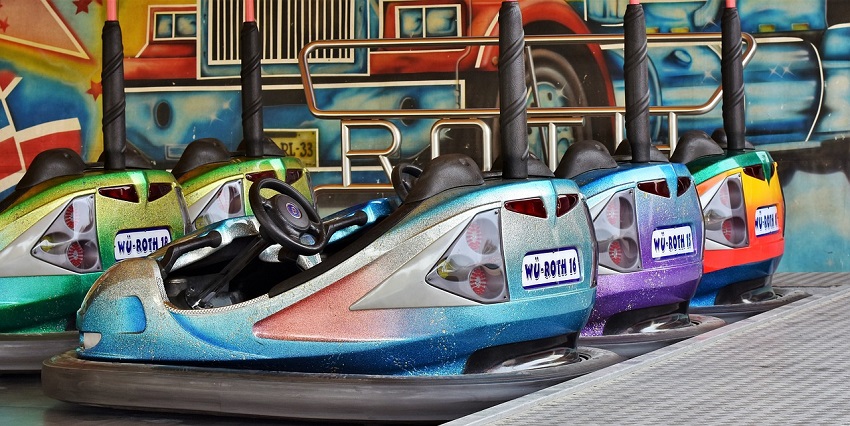 A picture of a few bumper cars parked at the play area in an amusement park