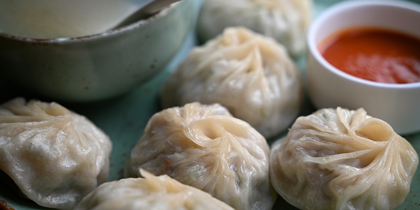 Close-up of a plate of steamed momos, a popular Tibetan dish, served on a plate in Mcleodganj