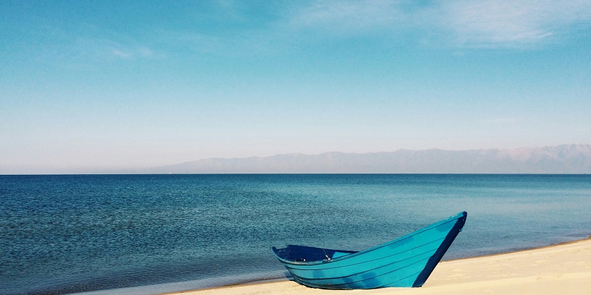 A view of the cobalt blue waters and golden sands decked with a boat at Morjim Beach.