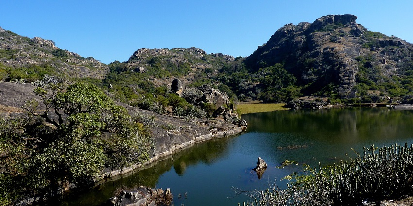 Mount Abu, with rugged terrain and lush greenery against a backdrop of clear skies.