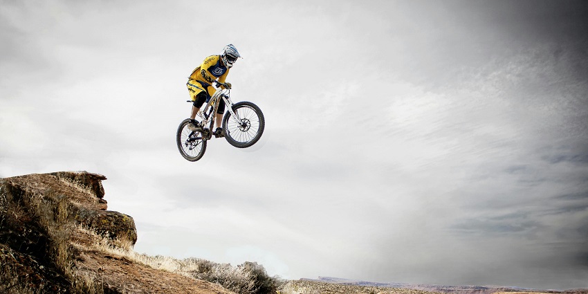 A fascinating view of a person enjoying mountain biking during the day under a clear sky.